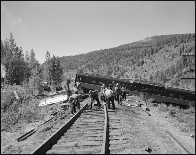 Car 304 is pulled by a Cat as crew straightens track. The North Coast Limited, derailed June 10, 1962 1 mile west of Evaro, MT taking one life.