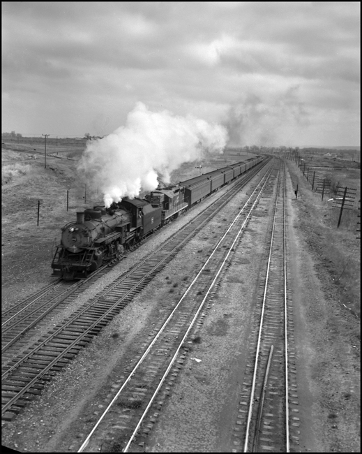 CBQ 4960, a 2-8-2 steam locomotive and a diesel helper with passenger cars east of Laurel, MT.