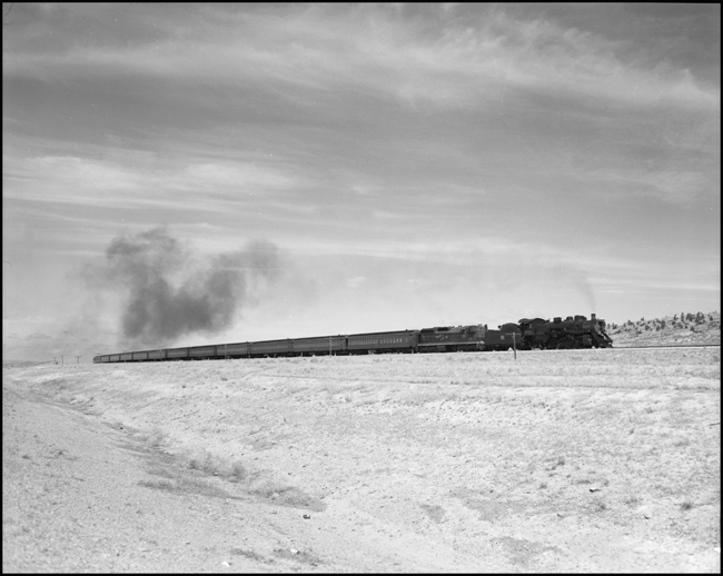 CBQ 4960, a 2-8-2 steam locomotive and a diesel helper with passenger cars south of Bridger, MT.