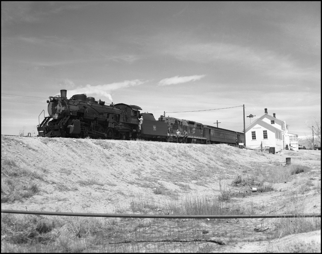 CBQ 4960, a 2-8-2 steam locomotive and a diesel helper with passenger cars stopped at Frannie, Wyoming.