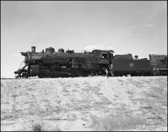 CBQ 4960, a 2-8-2 steam locomotive and a diesel helper with passenger cars stopped at Frannie, Wyoming.
