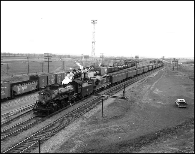 CBQ 4960, a 2-8-2 steam locomotive and a diesel helper with passenger cars at Laurel Yard, MT.