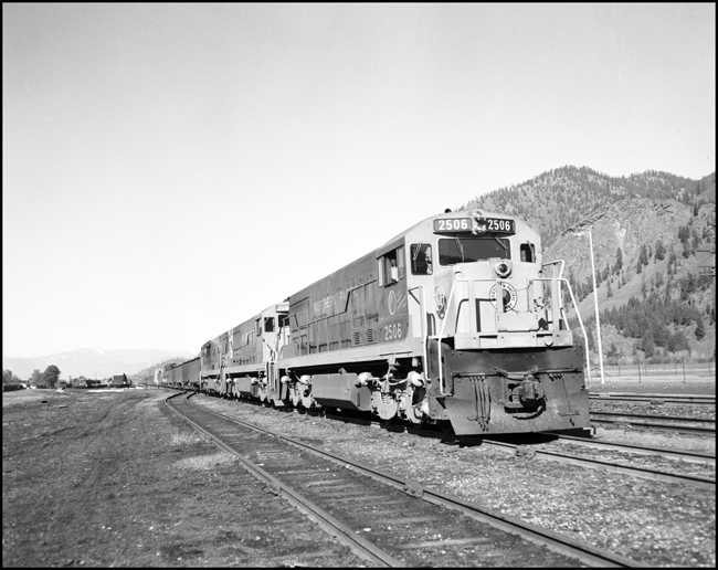 NP X2506E, with 3 U-25C locomotives pulling freight at Paradise, MT