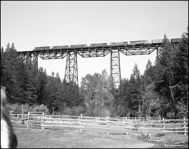 Six units lead westbound freight NP X3602W across Marent Trestle east of Evaro, MT.