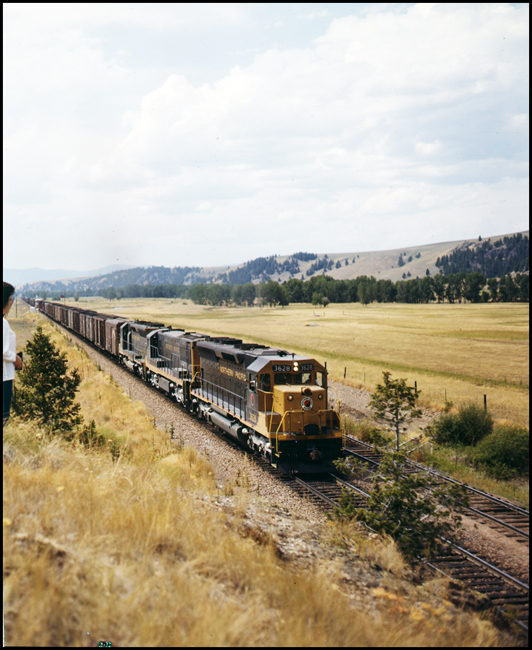 NP X3628E led by SD-45 no. 3628 runs along the valley near Elliston, MT.