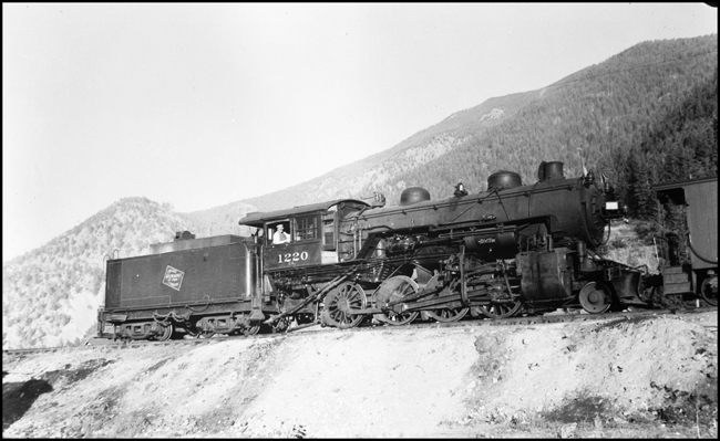 The engineer is in the cab of MILW 2-8-0 Consolidation no. 1220 as it switches a local freight at Bonner, MT.
