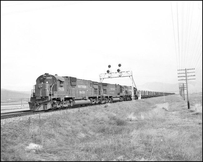 BN extra SP 7814W with 2 other SP Alcos on lease from SP on log train west of Missoula, MT.