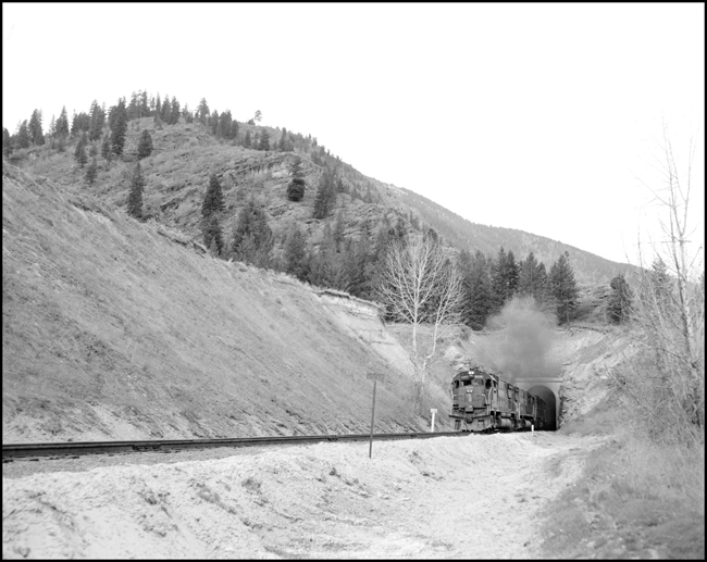 BN extra SP 7814W with 2 other SP Alcos on lease from SP on log train coming out of tunnel at Plateau, MT.