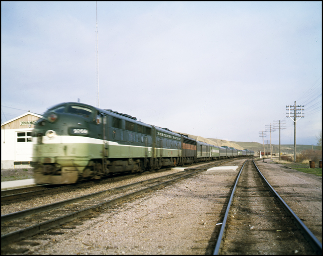Color photograph of BN passenger train #25, BN 9766, at Drummond, MT.  This is the last acheduled BN run of this train.  There are nine cars in train.  Bn crew is Eichhorn, Boyd, and Johnson.