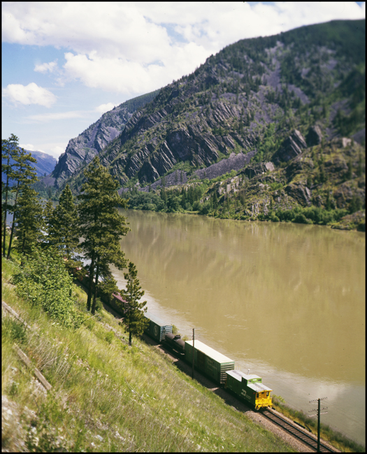 Color picture on BN extra east rear of train with BN caboose near Woodlin, MT.