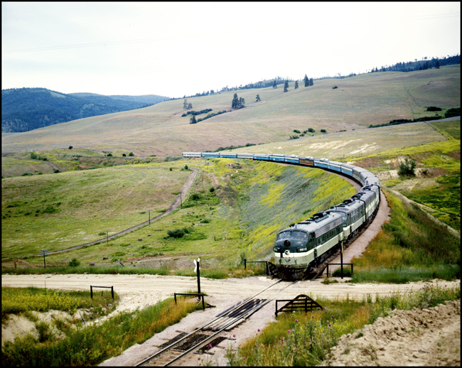 Color picture of Amtrak passenger train east bound with BN 9802 on point in NP paint near Nagos, MT.  Second F unit in consist is an A unit in NP paint.