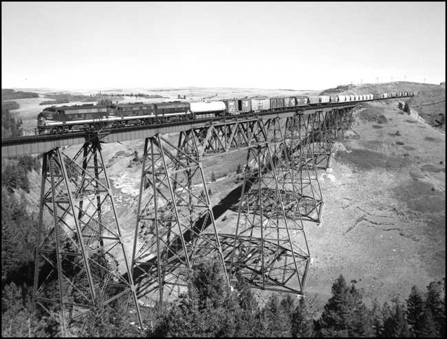 BN XW on bridge east of Glacier Park, MT with 3 former NP F units as motive power.