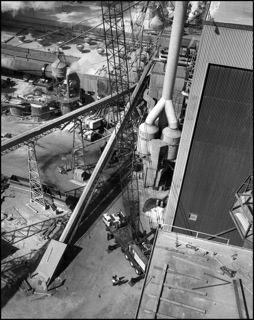 Overhead view from exhaust stack of Schilling Waldorf plant, with large Loraine highway crane from Grey's Crane and Rigging Co. at Portland on the ground making a tall lift.  Crane weighs 200 Tons and has a 240 foot boom and rides on 18 tires on 6 axles.