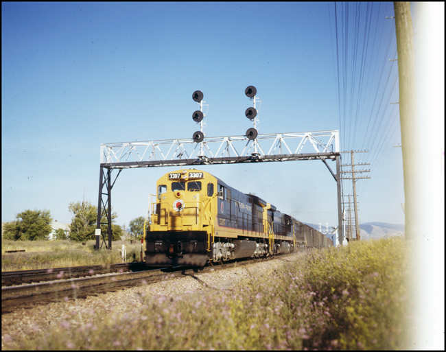 NP X3307W GE U-33C locomotive with 2 more GE's pulling freight near DeSmet, MT. Date this photo was taken is not available, but all NP Hi HP locomotives were renumbered by the end of 1970, so this photo is assumed to be during 1970.