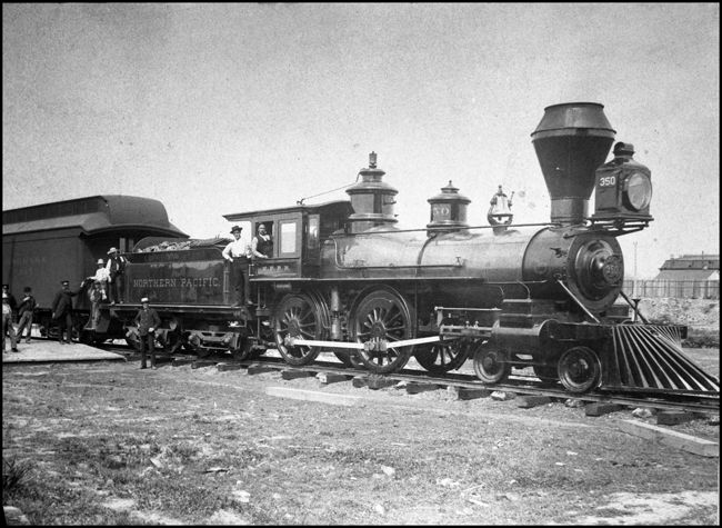 NP 350, 4-4-0 in butte with bystanders looking on. 