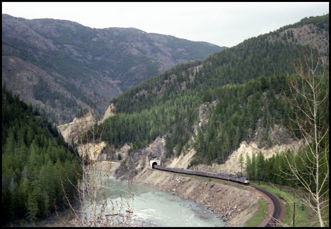 BN Train No. 7 with AMT 244-234-576 pulling Amtrak No. 7 exiting tunnel east of Belton, MT.