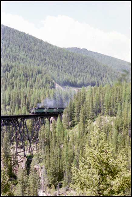 BN X6519E with BN 6519-BN 6400-BN 6431- BN 6563 on trestle bridge east of Essex, MT