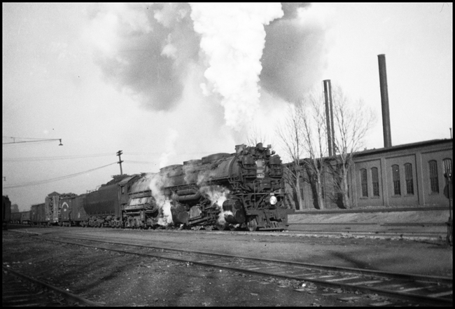 A Z-6 Challenger,  one of 21 such engines on the NP is passing Missoula with a  freight extra.  The NP owned one of the larger fleets of 4-6-6-4's in the U.S., using them on higher priority mainline freights.