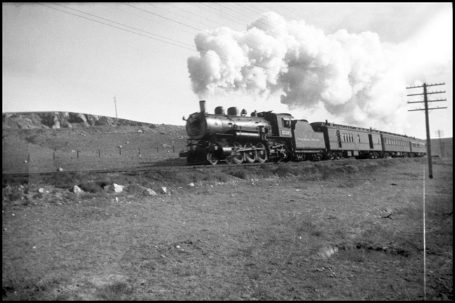 North Coast Limited passengers transferring to Helena got to ride this little train, a baggage rpo and a pair of coaches the followed the primary freight route while the Limited took the high road to Buttwe.  A Q-1 Pacific is in the lead.