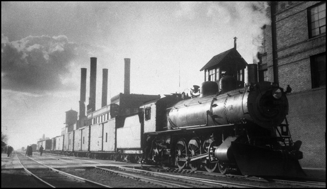 If Monet had turned his attention from water lillies to locomotives the result may have looked like thislate winter scene.  An eastbound local freight is crossing Main Street.  The passenger station platform, with waiting passengers is at the far left.  A 1906 ALCO Q-1 Pacific is the power.