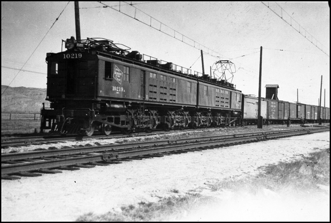 MILW electric locomotive 10219 pulling freight train near Willow Creek, MT.