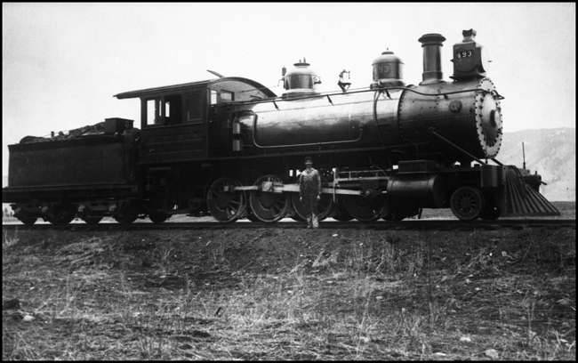 NP 493, later renumbered to NP 65, Class F-1 with mechanical person standing beside locomotive.