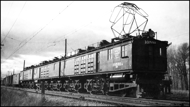MILW electric locomotive 10501 with pantograph arm up and pulling freight at Willow Creek, MT