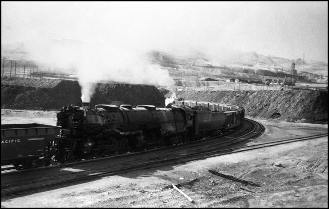 NP XE train leaving Butte with NP 5103, Class Z-6 helper cut in ahead of stock cars at the end of train.