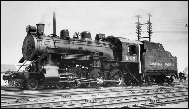 CPR 642, 4-6-0 locomotive in Winnipeg yard.  Workman fouling with switch stand behind locomotive.