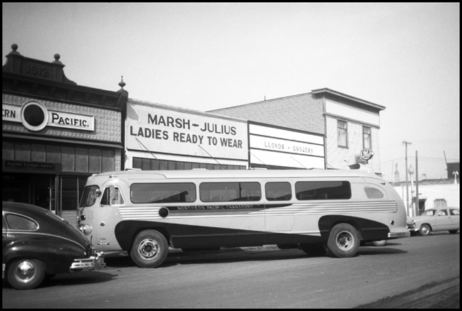 NP Transport bus parked in front of bus station in what may be Polson, MT