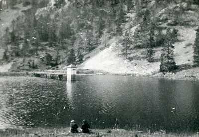Mystic Lake Scenic View with the dock and two people seated along the bank.