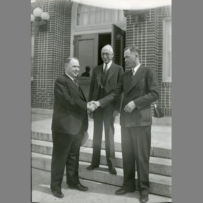 A. L. Strand shaking Governor Roy E. Ayers hand, 1938