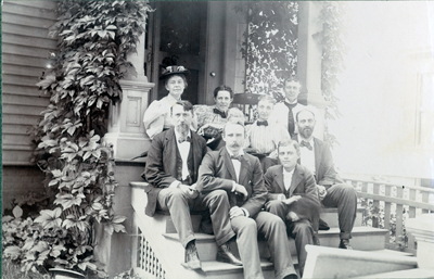 William M. Cobleigh, bottom right, Sitting on Porch with Others, 1895