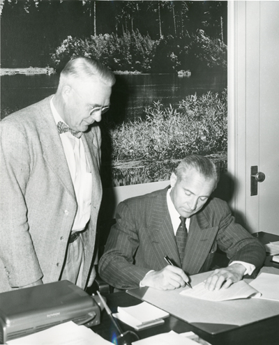 Roland R. Renne Signing a Document