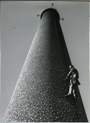 A young man climbing the Heating Plant smokestack, 1922