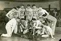 Basketball Team in Romney Gym studying plays