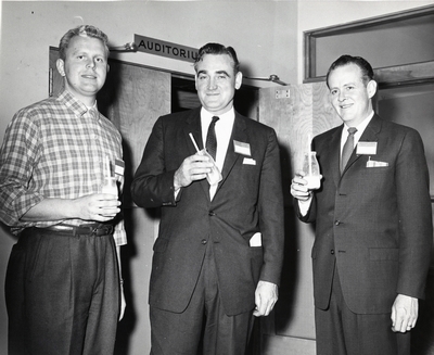 Three unidentified men pose for a photo with glasses of milk at the D.M. Short Course, 1958-1959