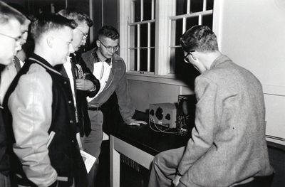 Students observe some type of electronic device.