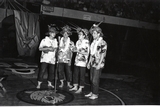 Four students dressed up in Hawaiian shirts and leis, playing the ukulele