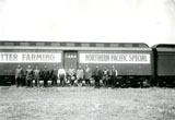 Group of people standing in front of the Better Farming Northern Pacific Special train.