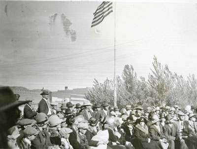 Crowd of people gathered near flag pole at the Better Livestock Special