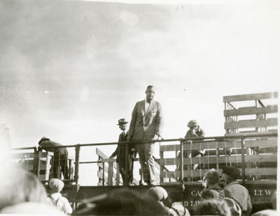 Man addressing a crowd from a flatcar of the Better Livestock Special Train