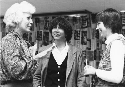 Three women laugh and talk at the Women Aware Conference
