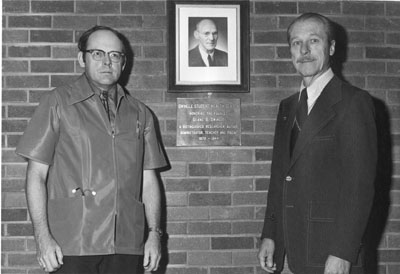 William G. Walter and Dr. Don Cheever stand in front of the Swingle Student Health Center plaque.