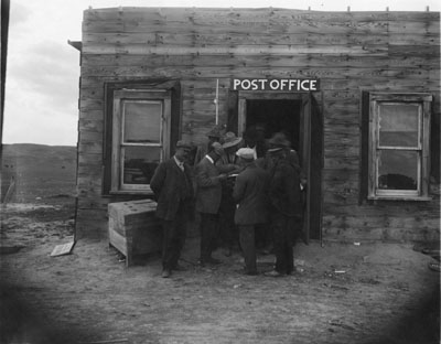 Men standing outside of a post office in Circle, MT, part of the M.L. Wilson flax series, 1912