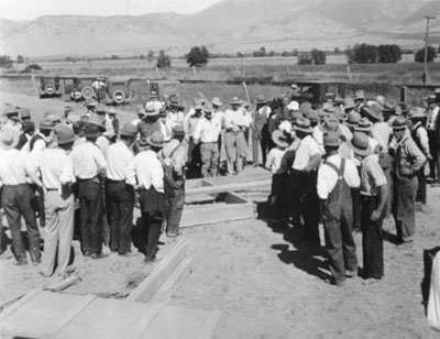 Men gathered around for a building demonstration