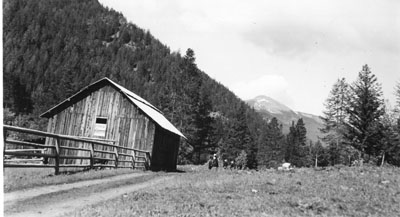 Harriette Cushman and others near a forest barn and corral