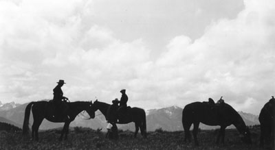 Silhouettes of 4 horses and 3 people