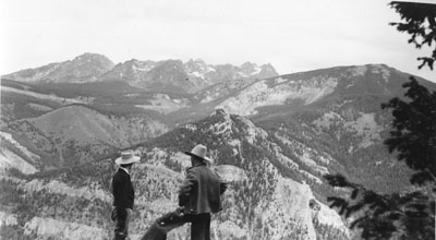 Two cowboys looking out over the mountain view