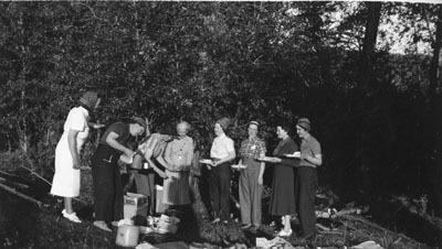 Group of women standing in line to get food for a picnic
